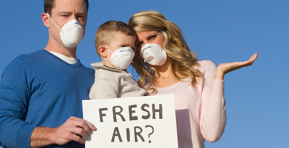 Family Standing with a sign reading Fresh Air? Dirty air is air pollution and affects infection rates of diseases.
