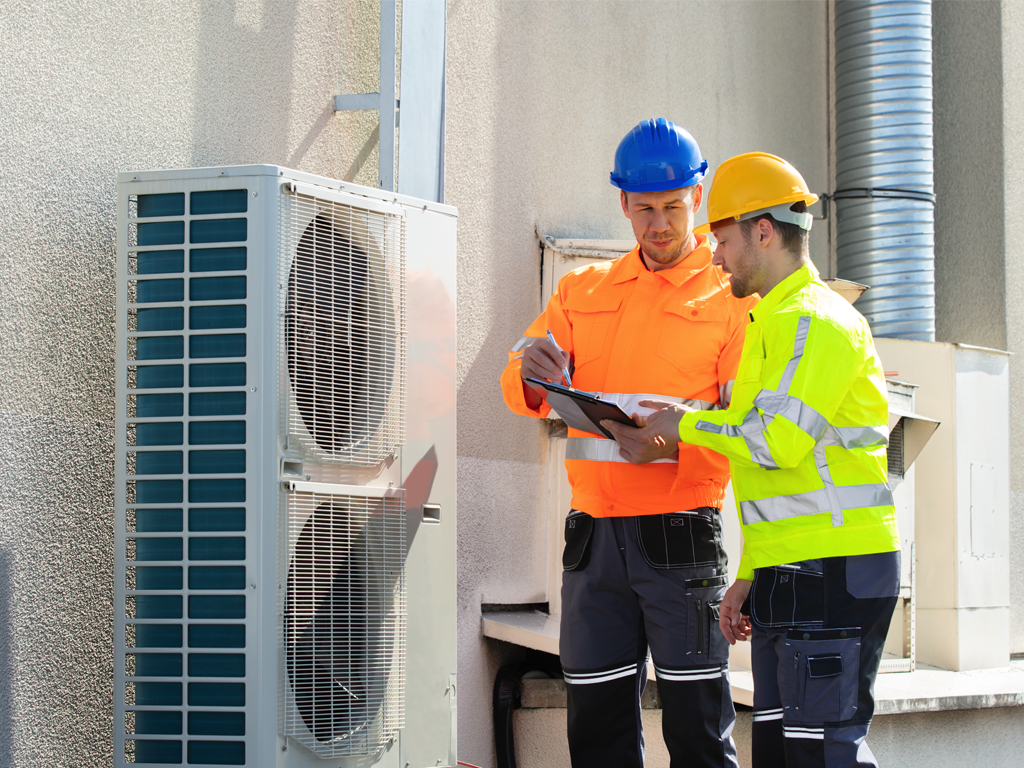 Two HVAC technician inspecting a commercial HVAC system
