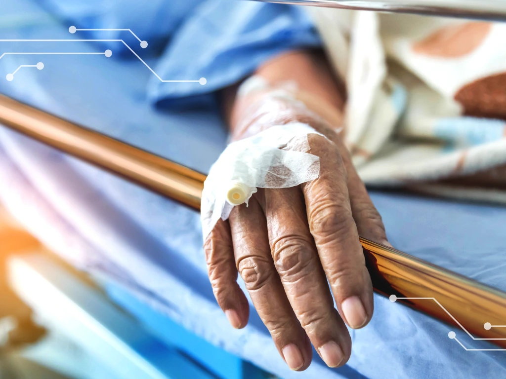 A patient's hand resting on a hospital bedrail with an IV catheter attached; ActivePure Technology has been shown to reduce HAIs in a hospital setting and is an emerging technology that will be found in many of the hospitals and skilled nursing facilities around the nation.