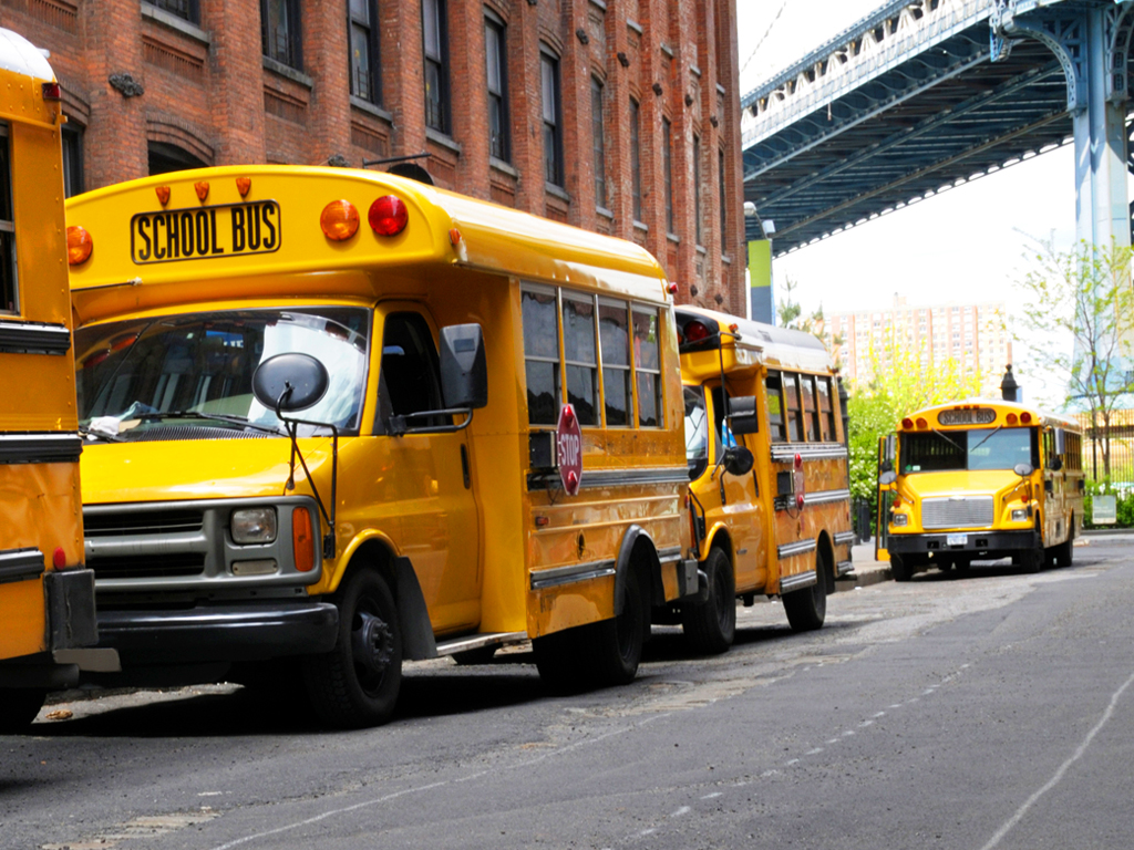 School busses lined up in a New York City Street; this will be a more common occurrence as school districts become more urban.
