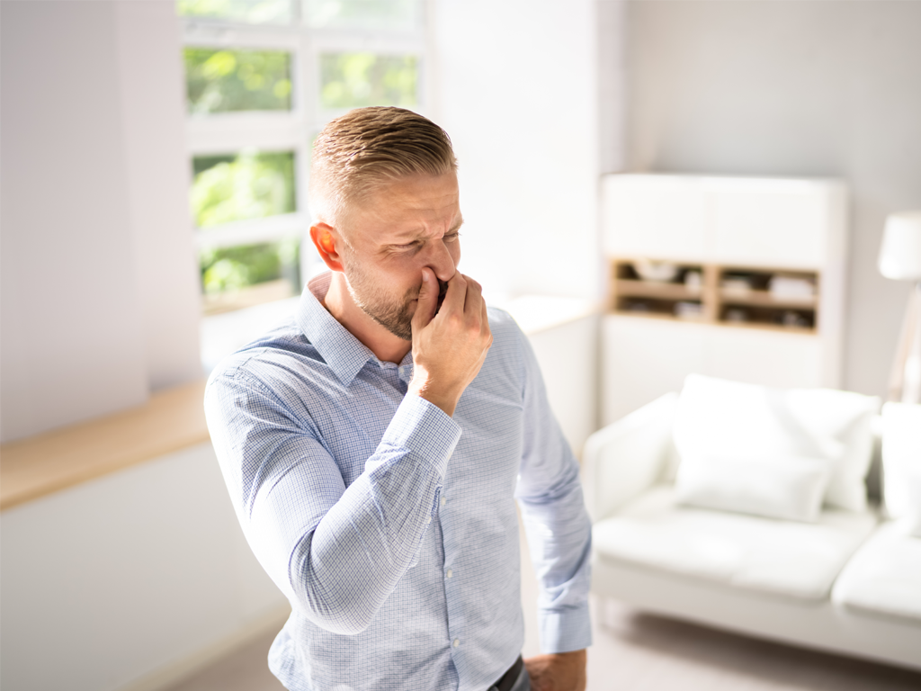 A man holding his nose, smellbusters is a program by Aerus that customized indoor air quality and odor issues in residential and business environments.