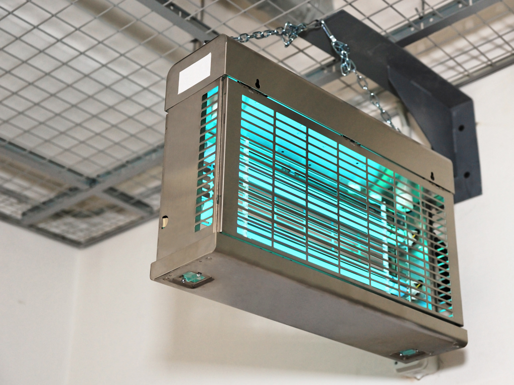 An upper room UVGI unit hanging from a ceiling.