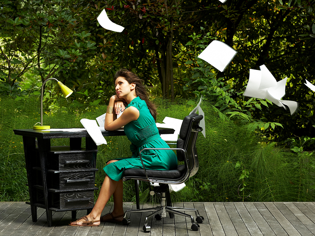 A woman sitting at a desk outside with papers blowing off the desk, Particulate matter could somewhat be eliminated by sitting outside, depending on outdoor air quality, but it would be much easier to invest in an air purifier or air cleaner.