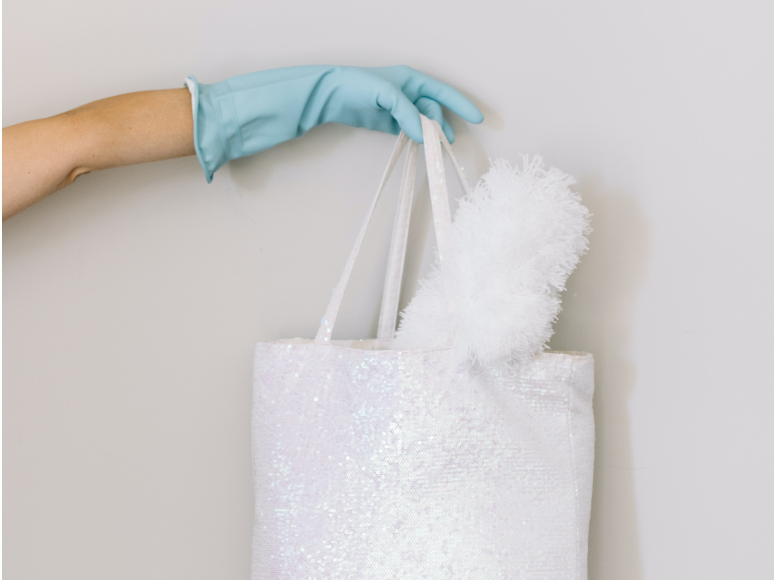 A person with a rubber glove holding a bag, contaminants cling to objects, such as the bag, just like ions attach to particles in the air.
